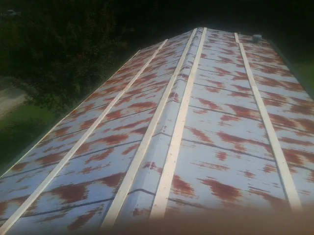 Rusted metal roof panels with new wood purlins before replacement — Storm Damage Roof Repair in Jeffersonville by Roofing Brothers