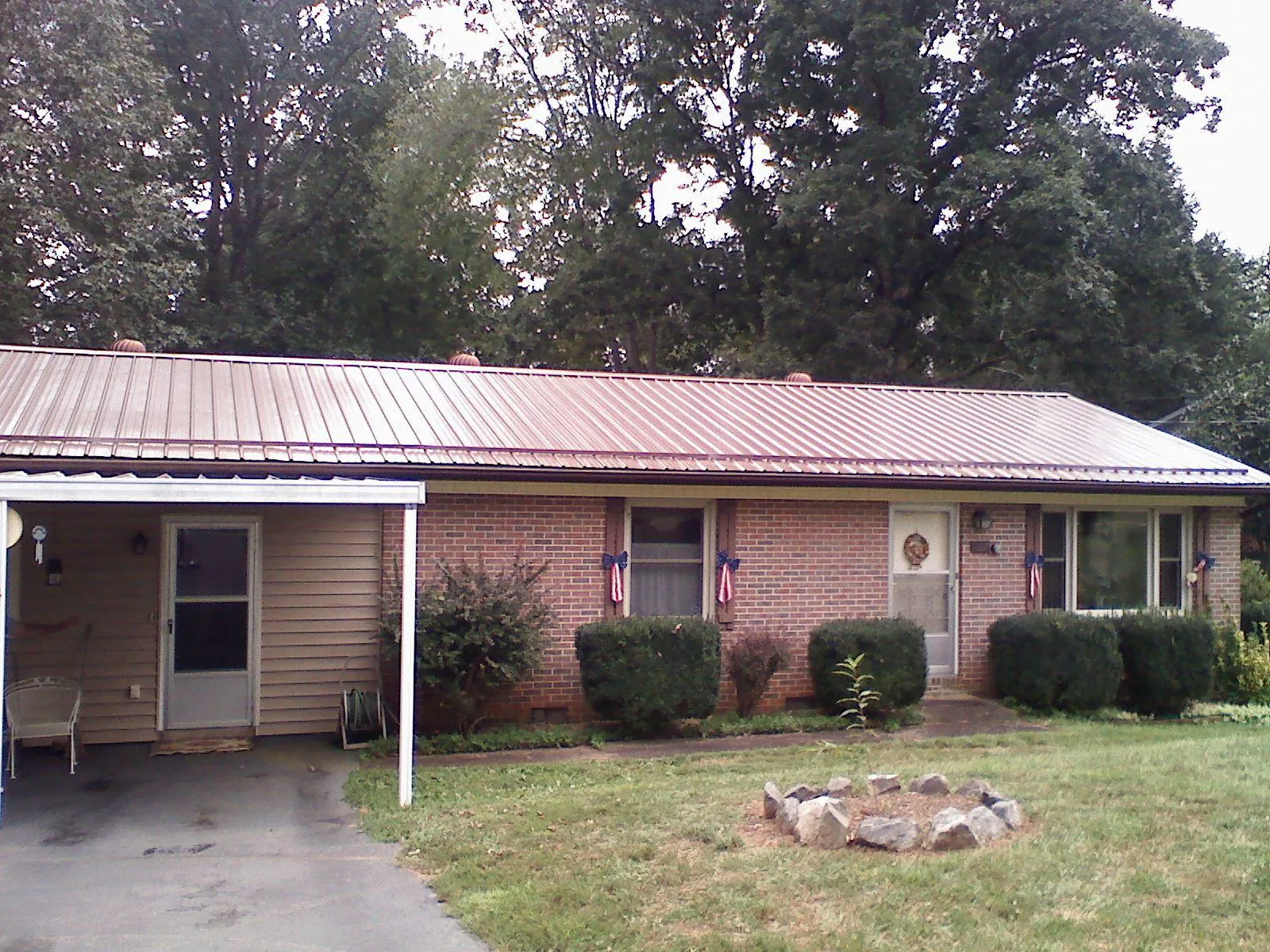 Bronze metal roof and carport on a brick ranch home — Roof Repair work by our crew in Jeffersonville